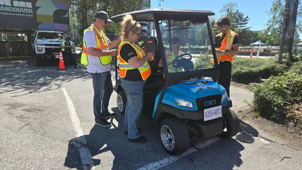 Event staff in high-visibility vests gathered around a HeyYa cart