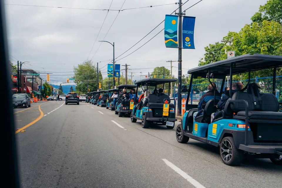 A long line of HeyYa carts travelling together along a Vancouver street