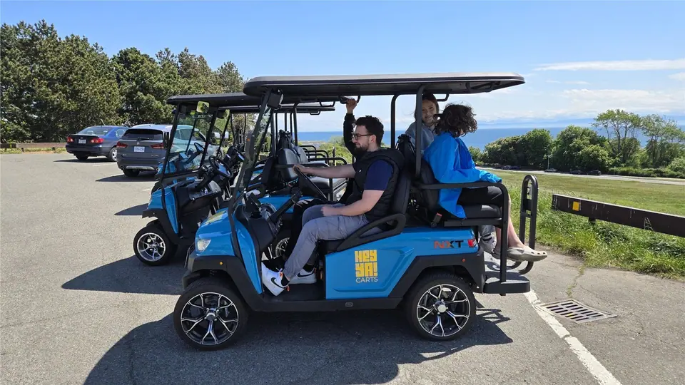 Passengers enjoying a HeyYa cart ride by the water in Victoria